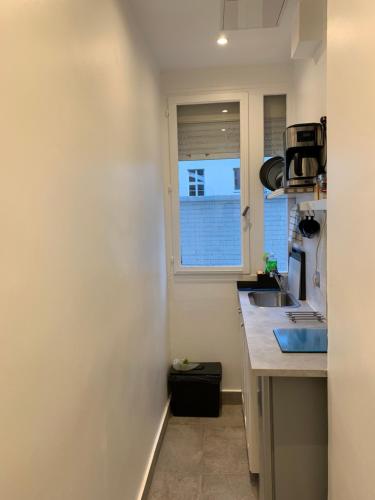 a small kitchen with a sink and a window at PARIS /LA DÉFENSE 5 MM DE L’ARC DE TRIOMPHE in Courbevoie