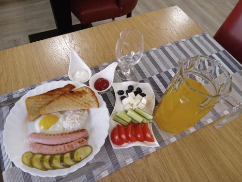 a plate of breakfast food with eggs sausage and vegetables at Kaspi Hotel in Uralsk