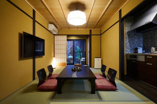 a dining room with a table and chairs at Miro Hachijo Uchidacho Tei in Kyoto