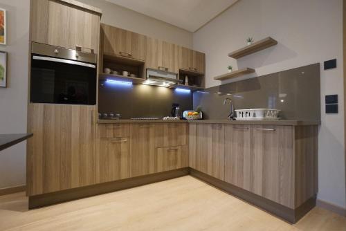 a kitchen with wooden cabinets and a sink at Flamant Rose Appart Hotel in Tangier