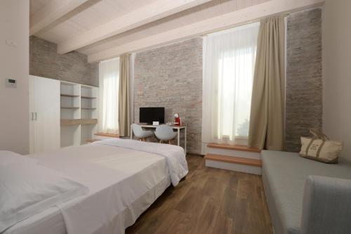 a bedroom with two beds and a desk with a computer at Club del Sole Vigna sul Mar Family Collection in Lido di Pomposa