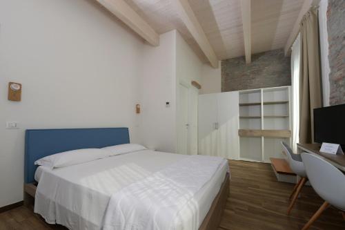 a bedroom with a large white bed and a television at Club del Sole Vigna sul Mar Family Collection in Lido di Pomposa