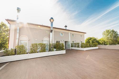 a large white building with plants in front of it at Club del Sole Vigna sul Mar Family Collection in Lido di Pomposa