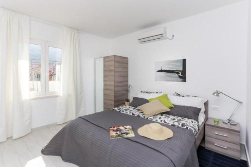 1 dormitorio con 1 cama con sombrero en Apartments Villa Providenca, en Dubrovnik