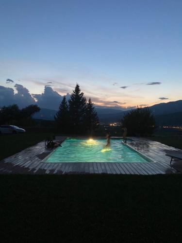 a person in a swimming pool at sunset at Ca l’Andreu Suites in Alás