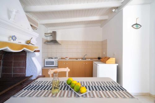 a kitchen with a table with a plate of fruit on it at PaxosBlue Suites & Villas in Gaios