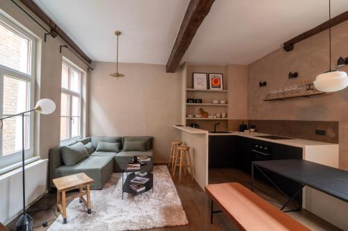 uma sala de estar com um sofá e uma mesa em Charming House in Le Sablon em Bruxelas