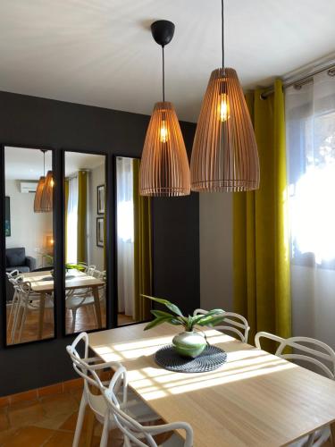 a dining room with a table and two chandeliers at Hotel Les Suites - Domaine de Crécy in Crecy la Chapelle