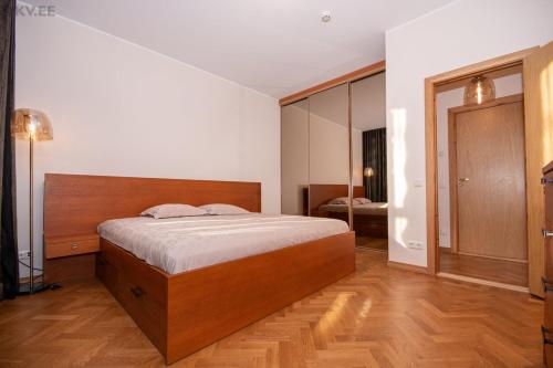 1 dormitorio con cama y espejo grande en Stylish apartment in the heart of Pärnu, en Pärnu