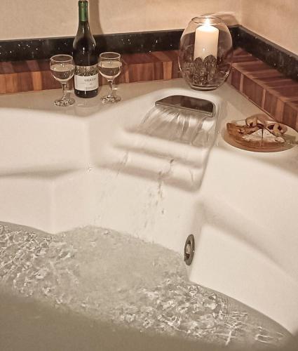 a sink filled with water with two glasses of wine at B&B Romeo in Santarcangelo di Romagna