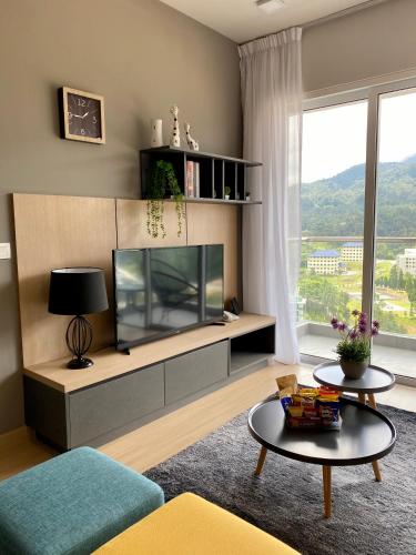 a living room with a large fish tank on a cabinet at 2 Bedroom Apartment (Windmill Upon Hills, Genting Highlands) in Genting Highlands