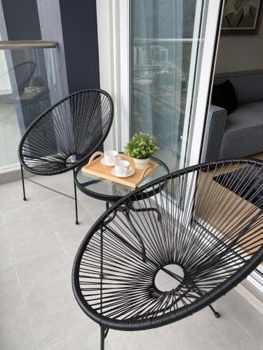 two chairs and a table with a tray on a balcony at 2 Bedroom Apartment (Windmill Upon Hills, Genting Highlands) in Genting Highlands