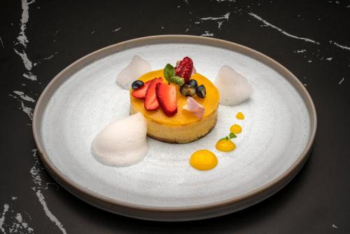 a dessert on a plate with fruit on it at Meliá Frankfurt City in Frankfurt/Main
