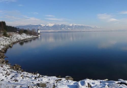 a large body of water with a lighthouse in the middle at Apartmán AQUAPARK - Hotel Bešeňová in Bešeňová