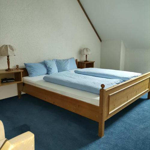 a bedroom with a large bed with blue pillows at Ferienwohnungen Kupferkanne in Todtmoos