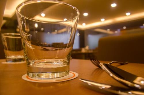 a glass of water sitting on top of a table at Hotel Comfotel Kolkata in Kolkata