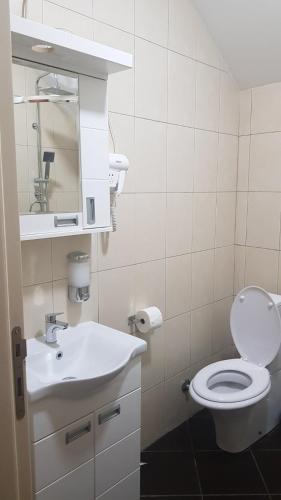 a bathroom with a white toilet and a sink at Aleksei Apartmani in Belgrade