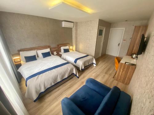 a hotel room with two beds and a blue couch at ERA PALACE HOTEL B BLOK in Istanbul