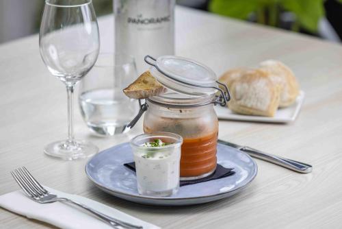 a table with a plate with a jar of jam and bread at Hotel Les Suites - Domaine de Crécy in Crecy la Chapelle