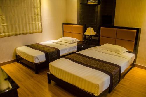 a room with two beds in a room at Hotel Comfotel Kolkata in Kolkata