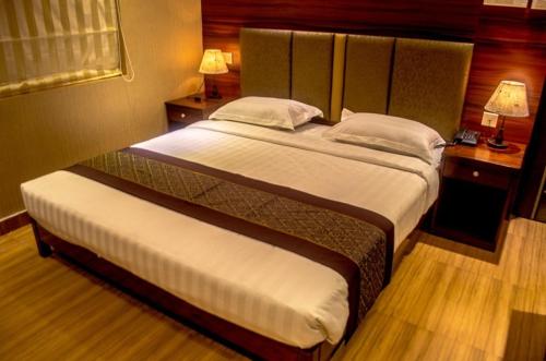 a bedroom with a large bed in a hotel room at Hotel Comfotel Kolkata in Kolkata
