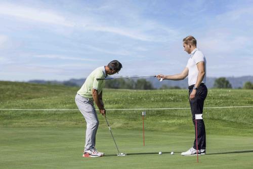 two men playing golf on a golf course at Hotel Les Suites - Domaine de Crécy in Crecy la Chapelle