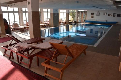 a large swimming pool with chairs and tables in a building at MILMARI CENTRAL Private apartments in Kopaonik
