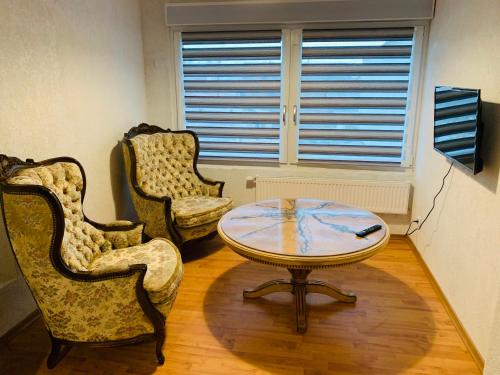 a living room with two chairs and a table at Apartment Marielena in Püttlingen