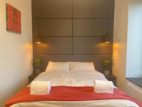 a bedroom with a large white bed with two pillows at Cardiff Arms Bistro & Hotel in Treorky