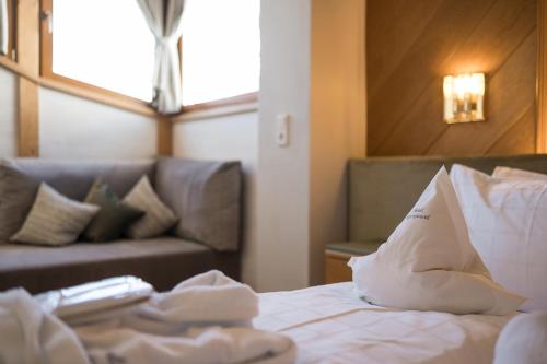 a hotel room with a bed and a couch at Hotel Alpenjuwel in Melago