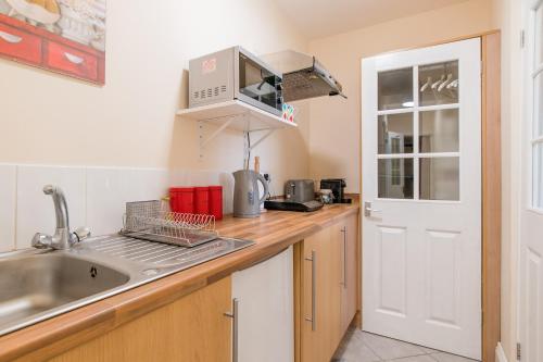 a kitchen with a sink and a microwave at High Banks studio in Sevenoaks