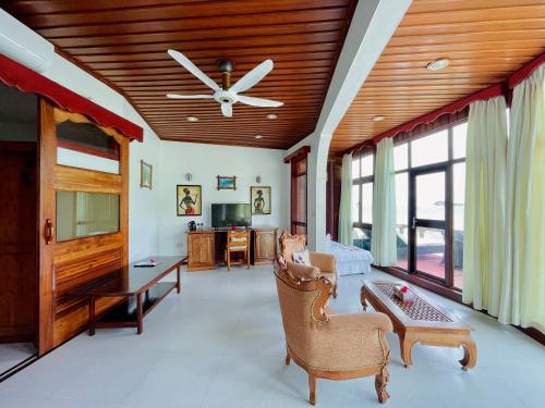 a living room with a ceiling fan and a couch at Villa Chez Batista in Takamaka