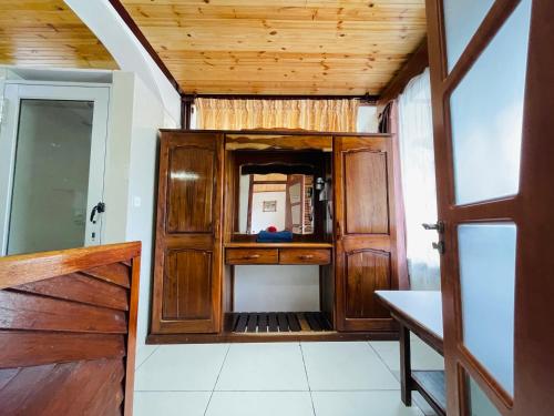 a room with a wooden cabinet and a door at Villa Chez Batista in Takamaka