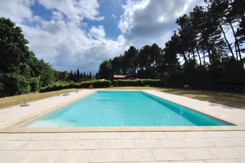a swimming pool with blue water in a yard at Relais jardin San Vivaldo in San Vivaldo