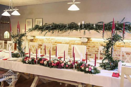 a table with red candles and flowers on it at Hotel & Restauracja Timberland in Orzesze