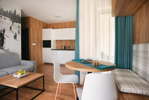 a living room with a table and a couch at Apartmány Štiavnica & Ďurková - Galeria Apartments Jasná Lúčky in Demanovska Dolina
