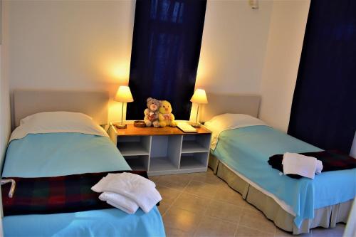 um quarto com duas camas e uma mesa com um ursinho de peluche em Manzara Apartment em Kas
