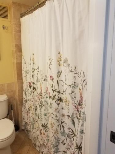 a bathroom with a shower curtain with flowers on it at 2417 at Oceanfront Resort Lihue Kauai Beach Drive Private Condo in Lihue