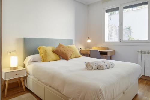 ein Schlafzimmer mit einem großen weißen Bett mit Handtüchern darauf in der Unterkunft Esnatuz - Basque Stay in San Sebastián