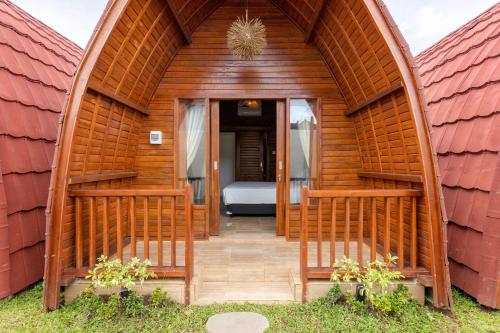 a wooden house with a bed in the middle at Les chalets Uluwatu in Uluwatu