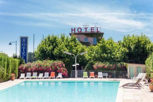 a hotel swimming pool with a hotel sign in the background at Logis VIGNES BLANCHES*** Hôtel Cosy et restaurant de terroir in Beaucaire