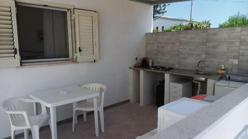 a small kitchen with a white table and chairs at Fronte Mare in Avola