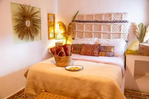 a bedroom with a bed with a bowl of food on it at Amayour Surf Hostel in Taghazout