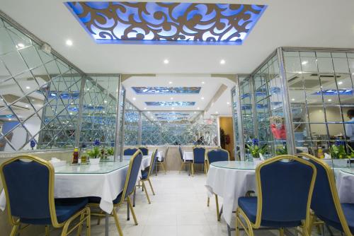 a restaurant with tables and chairs and a blue ceiling at Victoria Hotel in Dubai
