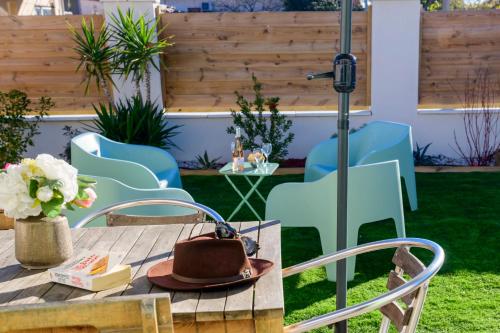 a patio with a table with a hat and chairs at Le Cabanon de Virginie in Salin-de-Giraud