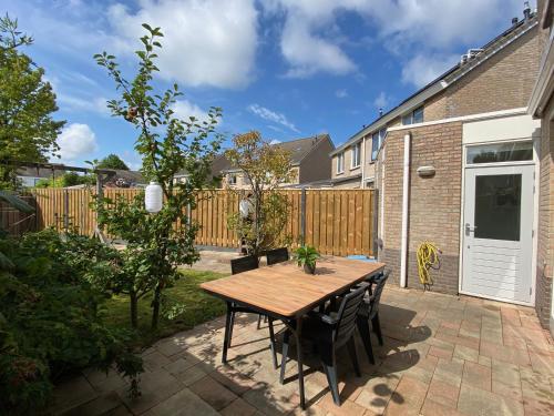 a patio with a wooden table and chairs at Vakantiewoning in Middelburg Zeeland in Middelburg
