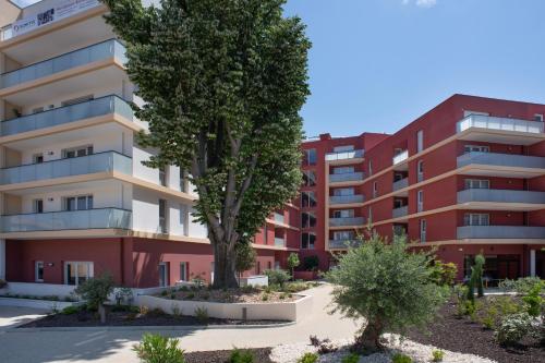 een appartementencomplex met bomen ervoor bij Domitys - La Majolique in Béziers