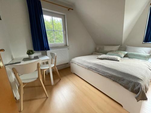 a bedroom with a bed and a desk and a window at Ferienhaus Strandoase in Zingst