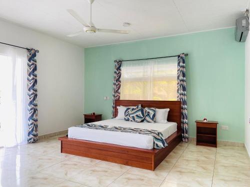 a bedroom with a bed with blue walls at Ocean Blue Bay in Anse Volbert Village
