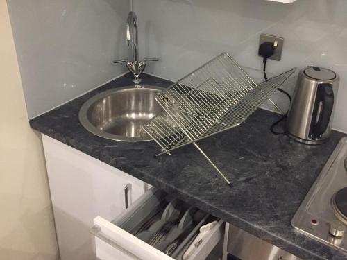 a kitchen counter with a sink and a fan on it at Showcase Apartments - Kimberley House in Leicester